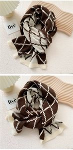 Detail showing thick brown and white argyle knit scarf with soft ribbed texture
