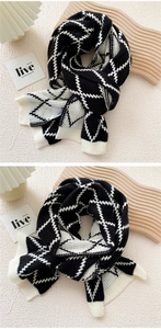 Detailed texture of thick black and white argyle knit scarf with premium stitching