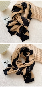 Detail showing thick knitted scarf with black and camel geometric diamond pattern texture