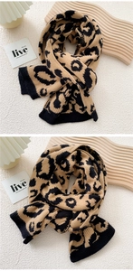 Detail of leopard print knitted scarf showing thick wool texture and black ribbed hem
