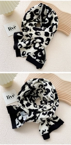 Detail of soft knit scarf with leopard pattern, ribbed edge and wash care label