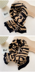 Detail of thick knit scarf with tiger stripe pattern showing soft premium texture