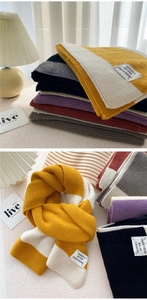 Detail of soft knit texture and color-block striped scarf with brand woven label