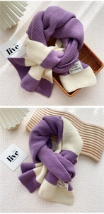 Detailed knit texture of a purple and cream striped scarf with a sewn brand label