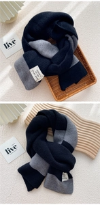 Close-up of thick knit two-tone striped scarf featuring ribbed texture and fabric label