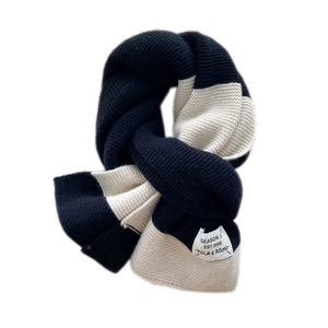 Thick knit black and white striped scarf with brand label on a clean white background