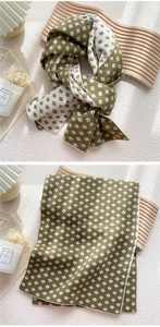 Detailed close-up of knitted olive and cream checkered winter scarf with cozy texture