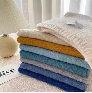 Detailed stack of soft solid color knitted scarves showcasing rich textures and vibrant colors