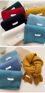 Close-up of thick knitted winter scarf texture and various color options with a woven label