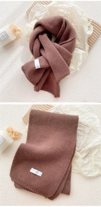Detailed macro view of the brown knitted scarf texture with ribbed edges and fabric label