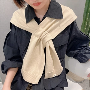 Creamy beige knitted shawl wrap in ribbed texture paired with black collared shirt