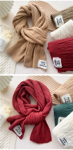 Detailed view of thick knit scarves with texture and minimalist brand tags