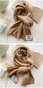 Close-up of camel knit scarf featuring waffle weave texture and premium fabric label