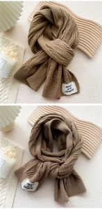 Macro detail of dark camel knitted scarf with thick ribbed texture and brand label