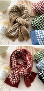 Detailed knit texture and heart pattern of winter scarves in multiple warm colors