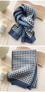 Detailed view of the heart pattern knitting and ribbed hem on the blue and white scarf
