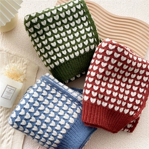 Thick knitted heart pattern winter scarf in red, green and blue with ribbed cuffs