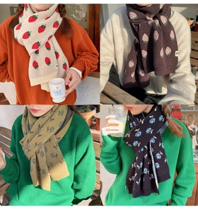 Close-up of winter knitted scarf patterns including strawberry and floral motifs