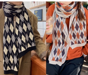 Detailed knit texture of Argyle patterned winter scarves with ribbed edges in two colors