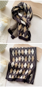 Detail of argyle knit scarf in brown and cream, showing dual-sided texture and fabric label
