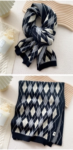 Detail of knitted scarf with black and white diamond pattern and soft wool-like texture