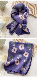 Detail of purple knitted scarf featuring pink floral patterns and ribbed cuff textures