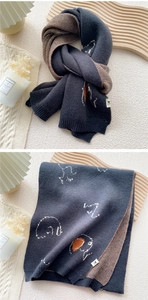 Detail of double-sided knit scarf with cat pattern and houndstooth texture in cozy setup