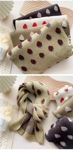 Detail of knitted strawberry pattern scarves in various colors with a ribbed edge finish
