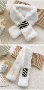 Close-up of white faux fur scarf featuring a black and white striped knit knot detail