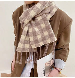 Détail d'une écharpe en maille à carreaux tons terre avec de larges franges rétro chic