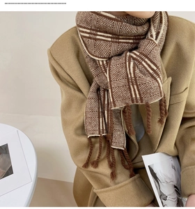 Détail d'écharpe en maille à carreaux marron et blanc avec finitions à franges