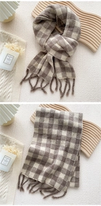 Détail de l'écharpe en maille à carreaux avec franges épaisses en beige et marron