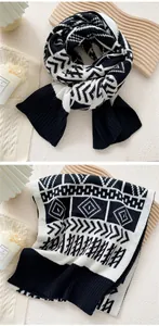 Detail of black and white knitted scarf showing geometric patterns and ribbed edges