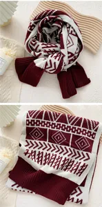 Close-up of red and beige jacquard knit scarf with geometric patterns and ribbed edges