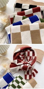Macro detail of thick checkered knit scarf showing soft texture and woven pattern