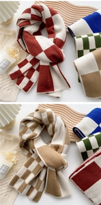 Detail of soft checkerboard knit scarves in red, blue, green and brown tones