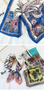 Detailed close-up of premium silk scarves with exotic floral patterns and elegant satin texture
