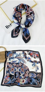 Close-up of a square silk scarf featuring a floral print and color-block design