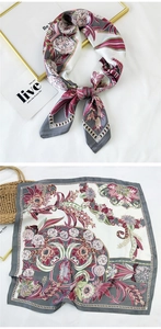 Close-up of floral print silk scarf with elegant vine patterns and geometric borders