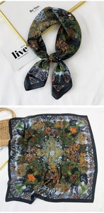 Detail of silk-feel square scarf with forest green and orange botanical floral patterns