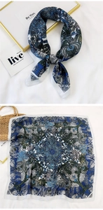 Close-up of blue and white mandala floral silk scarf with elegant satin finish texture