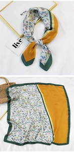 Detailed view of floral pattern square silk scarf with ginger yellow contrast borders