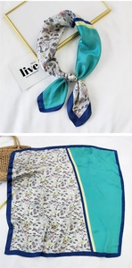 Detail of square silk scarf showing floral print and teal satin splicing with blue hem