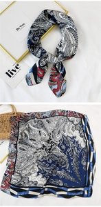 Detail of navy blue paisley silk scarf with geometric border on minimalist background
