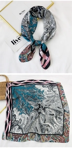 Close-up of square silk scarf with blue paisley patterns and striped borders