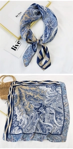 Detail of navy paisley square scarf showing intricate patterns and silky satin texture