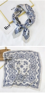 Detail of grey silk square scarf with blue paisley print and satin finish in light luxury style