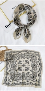 Detail of champagne gold silk-like square scarf with black paisley and floral patterns