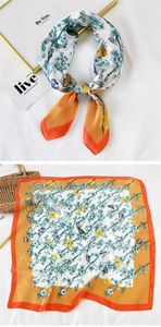 Detail view of a square silk scarf with floral butterfly prints and orange borders