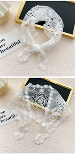 Vue détaillée du foulard triangle en dentelle blanche avec broderie florale ajourée
